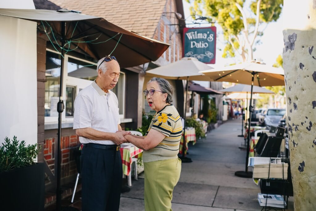 A senior couple holding hands while visiting a town.