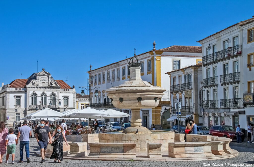 An image of tourists visiting the Praça do Giraldo, an attraction among the senior vacation spots in Portugal.
