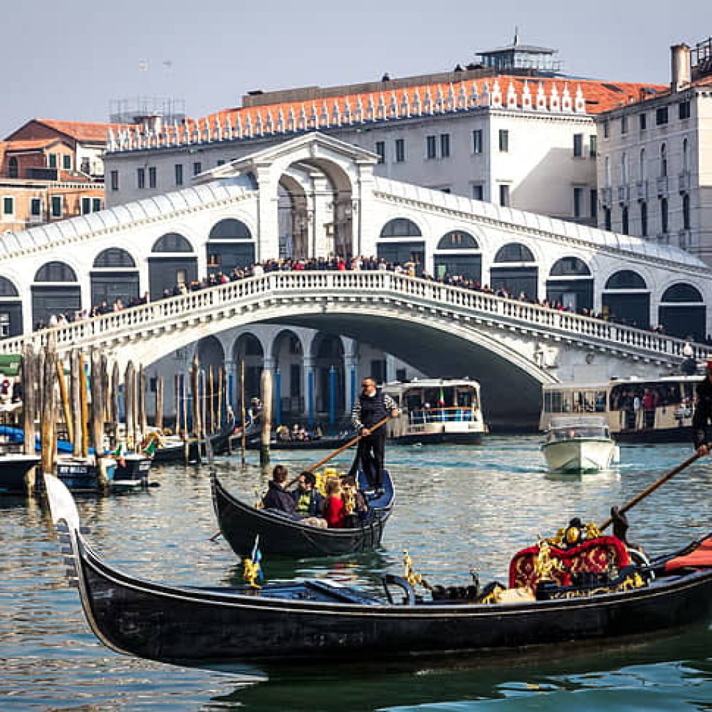 Tourists enjoying a boat ride during their senior vacation to Italy.